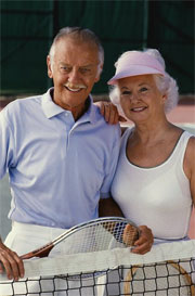 Aged couple playing tennis
